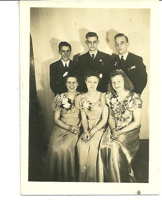 1940s vintage photo of a group (men & women) all dressed up in their 1940s dresses posing for photos. 