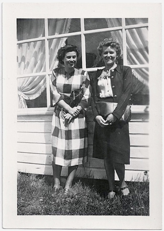 1940s vintage image of two women in 1940s fashions. 1940s plaid dress and 1940s skirt, blous and jacket. Cute 1940s hairstyles. 