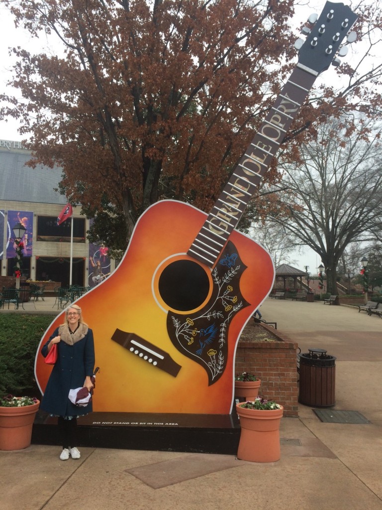 Grand Ole Opry Nashville-Vintage Inn Blog (Liz) posing with a giant guitar in a 1960s vintage Jacket. 