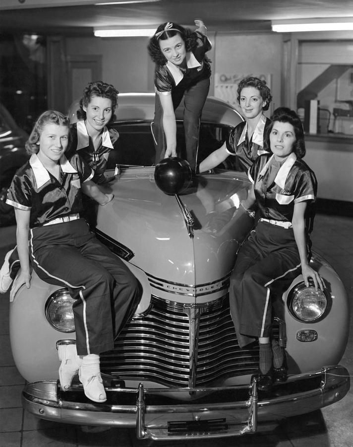 A women’s bowling team poses on the front of Chevrolet in a showroom. San Francisco, California 1945