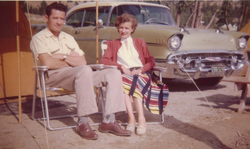 1950s vintage photo of a couple sitting in their lawn chairs in 1950s fashions by their 1950s car. 