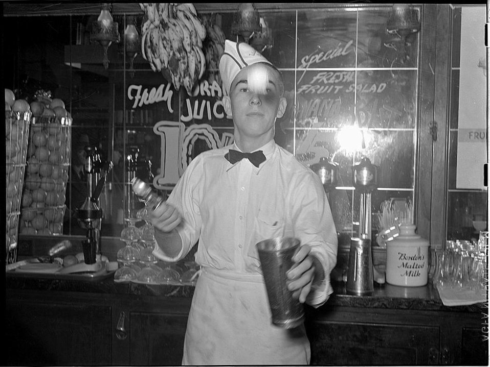 1950s vintage photo of a soda jerk in a malt shop making a milkshake. 