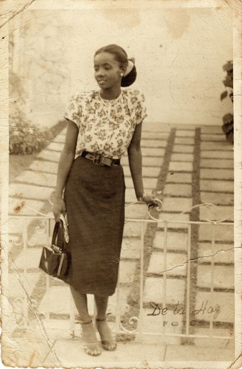 1950s vintage photo of a beautiful Black Woman posing in 1950s fashions. 