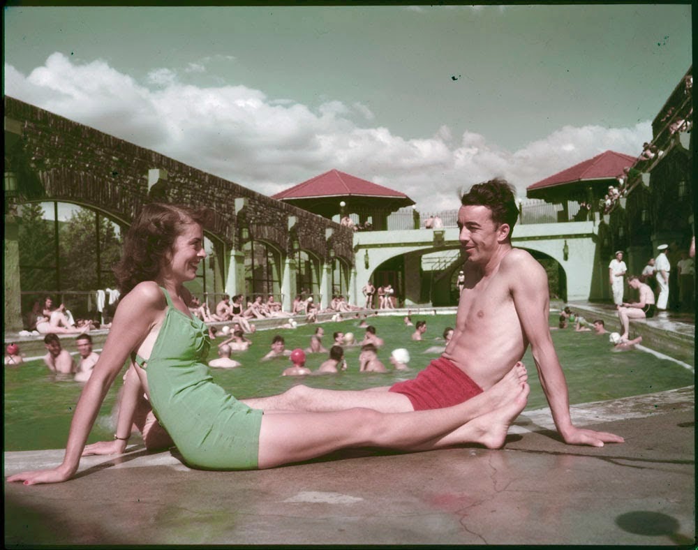 1950s vintage photo of a couple posing by a pool in Banff, Canada in 1950s swimsuits. 