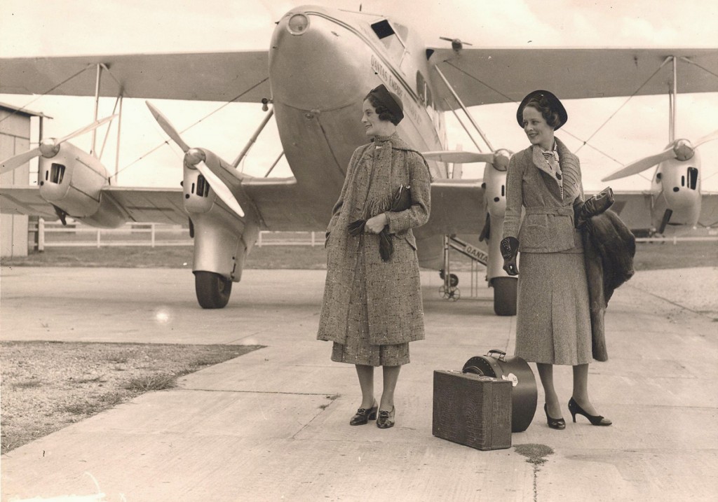 Travelling with Qantas- 1930s vintage photo of 2 women in 1930s fashion posing with an airplane. 