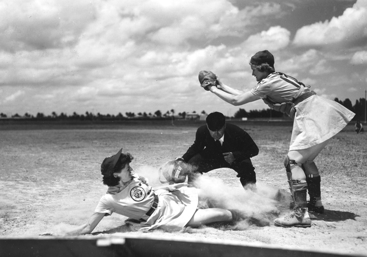 All-American Girls Professional Baseball League vintage photo featuring a women sliding into base in her dress uniform. 