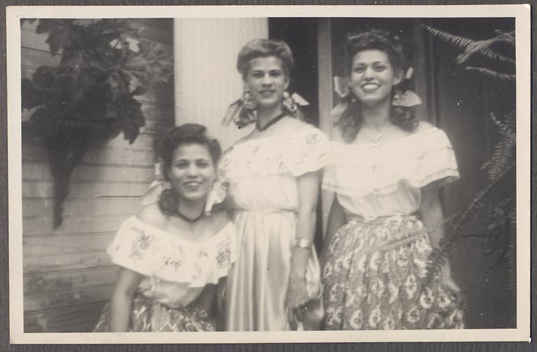 1940s vintage photo of 3 young women in spanish style outfits (peasant blouses) and bows in their curly hair and matching skirts. 