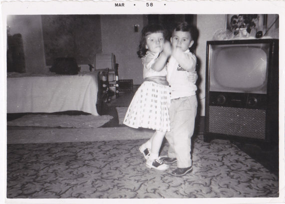 1950s vintage photo of children dancing in saddle shoes in front of a 1950s TV in March 1958