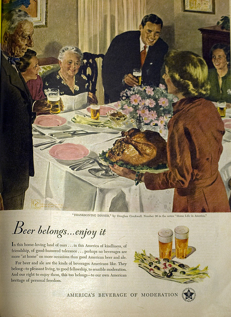 1940s vitnage ad for beer to be served with your Thanksgiving Turkey. Vintage illustration of a family sitting around the  thanksgiving dinner table. 