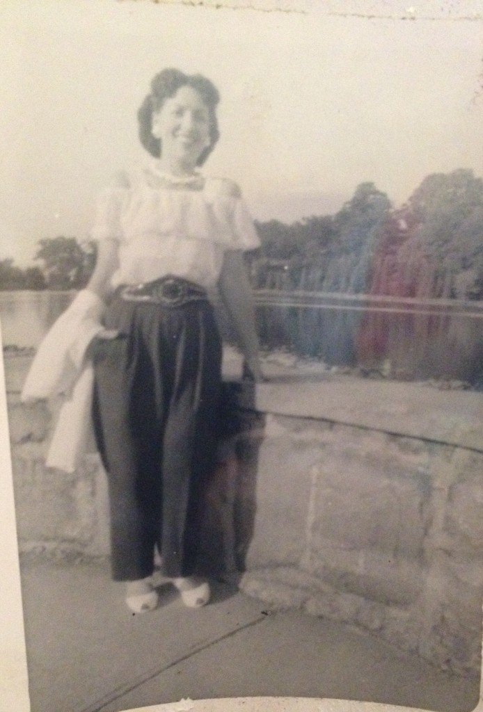 1940s woman in pants and spanish style blouse posing for this early 1940s photo