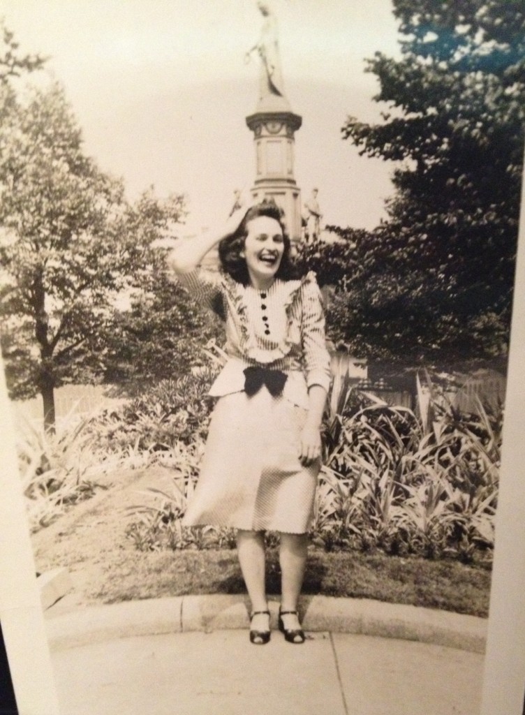 1940s Vintage Photo of a young women in a 1940s dress posing for a photo outside. 