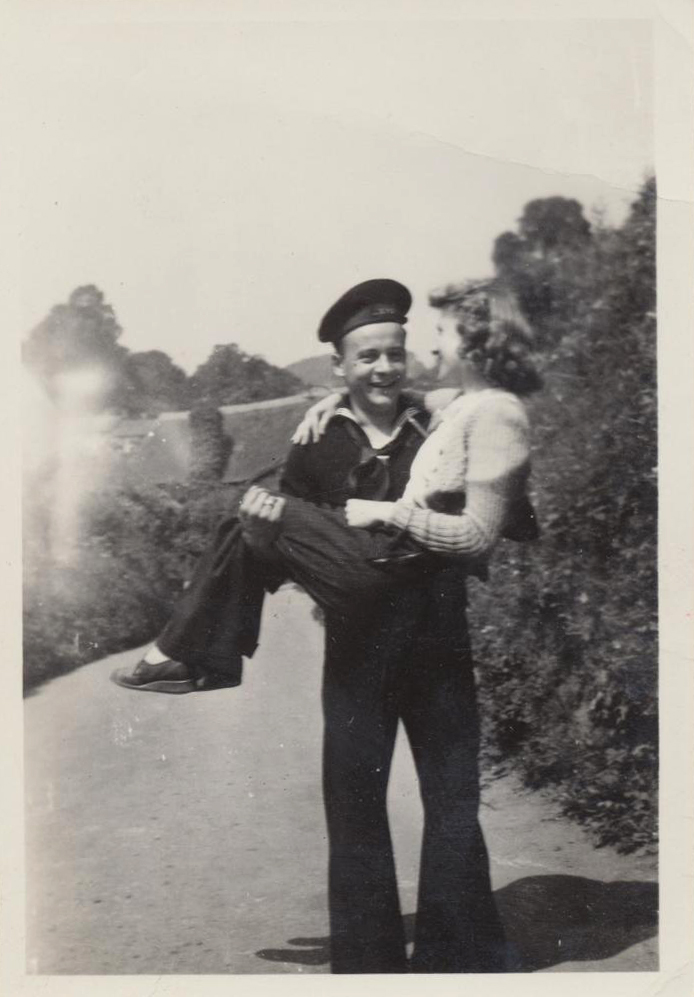 A cute 1940s photo of a young sailor sweeping his lady off her feet. 