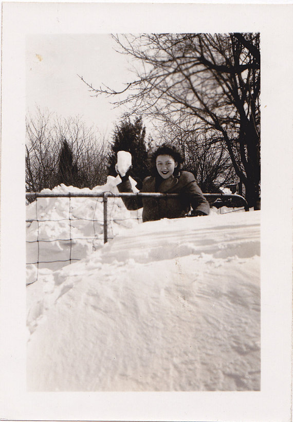 1940s photo of a 1940s woman in the snow about to throw a large snowball