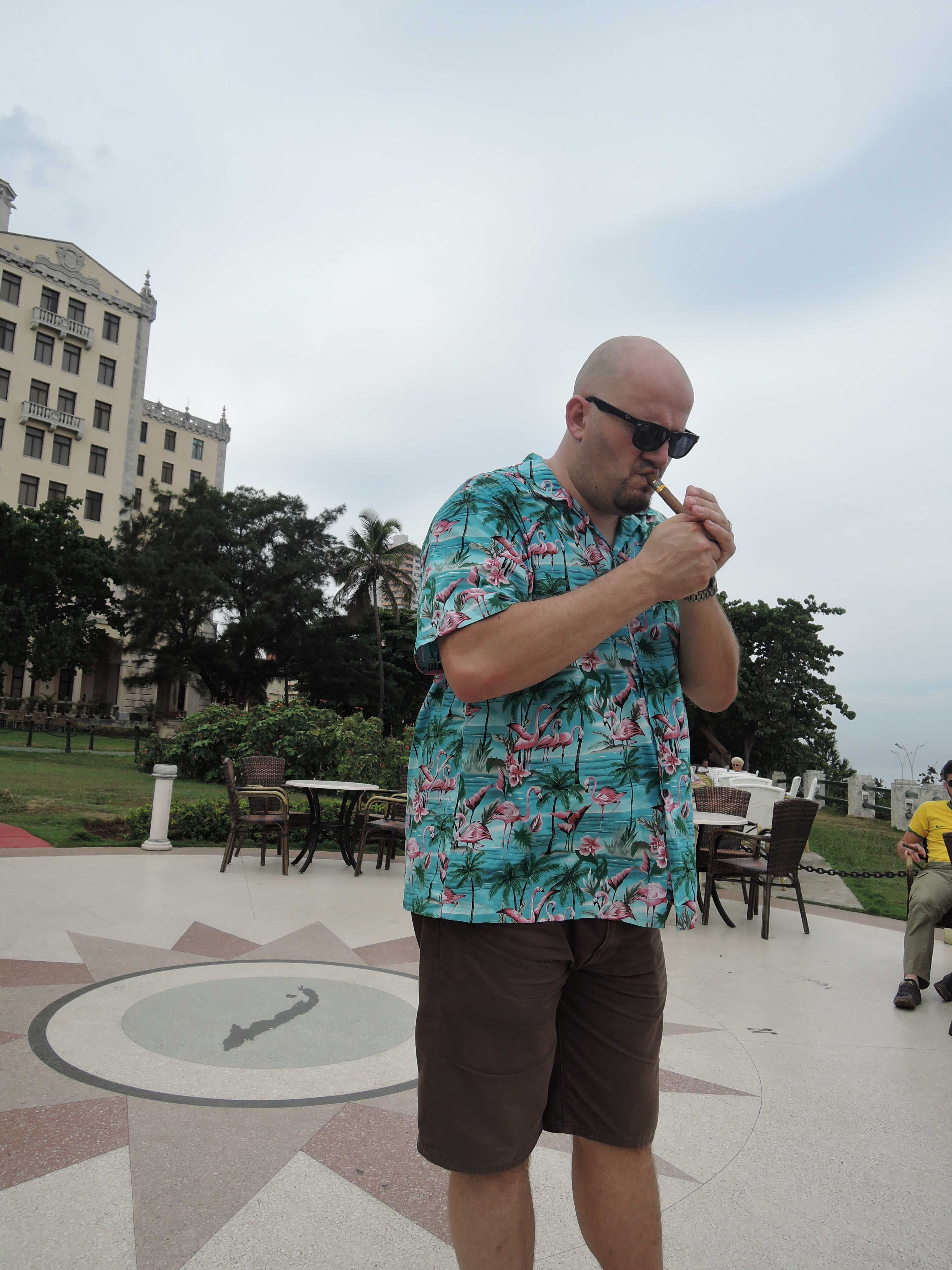 Hotel Nacional de Cuba enjoying a cigar outside by the water. 