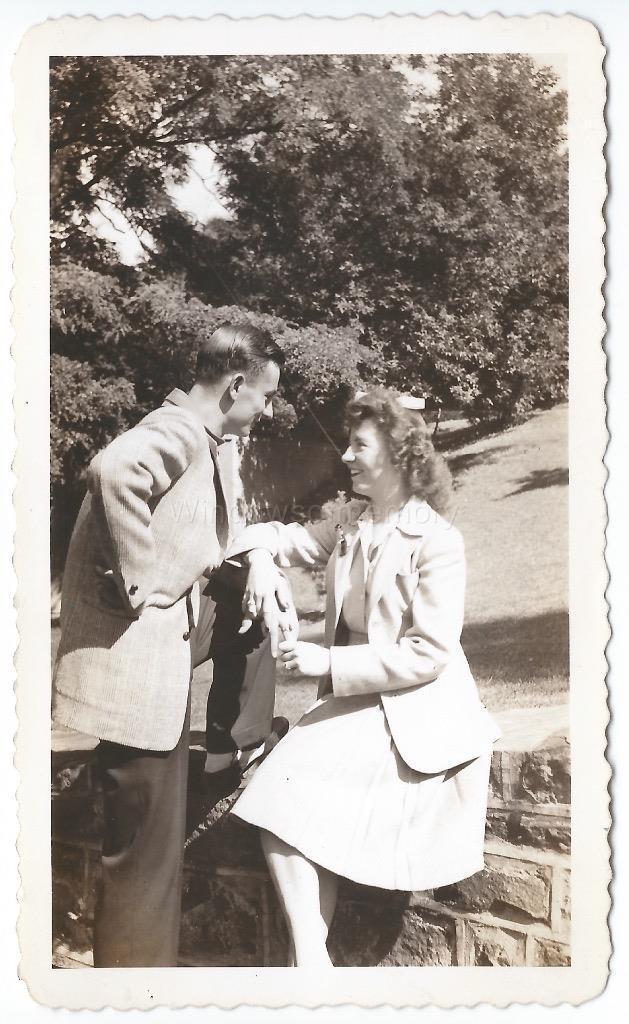 1940s vintage photo of a young couple IN LOVE staring into each others eyes in 1940s fashions.