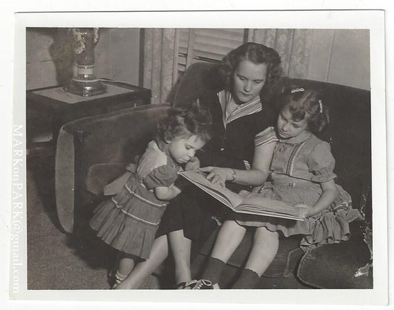 1950s vintage photo of a mother reading to her daughters 