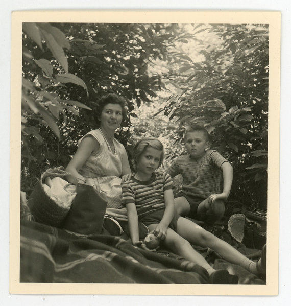 1950s vintage family photo of a mother with her two kids having a picnic together. 