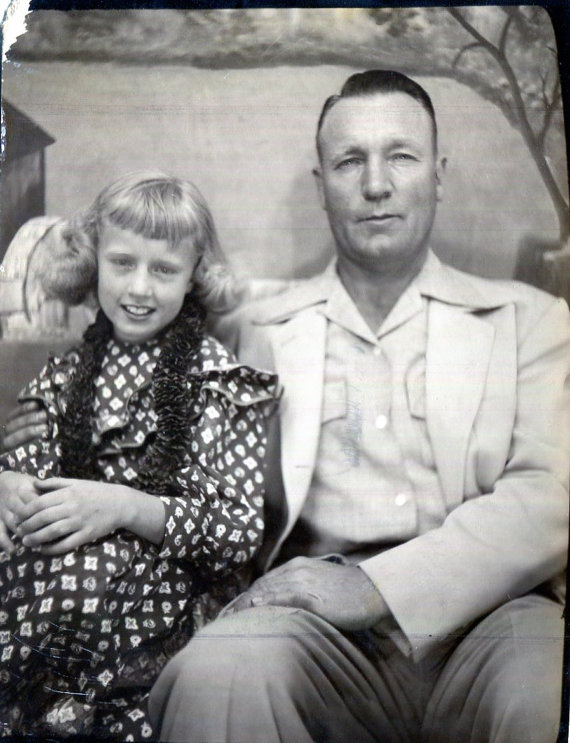 1940s vintage photo of father with daughter posing in a photo booth. 