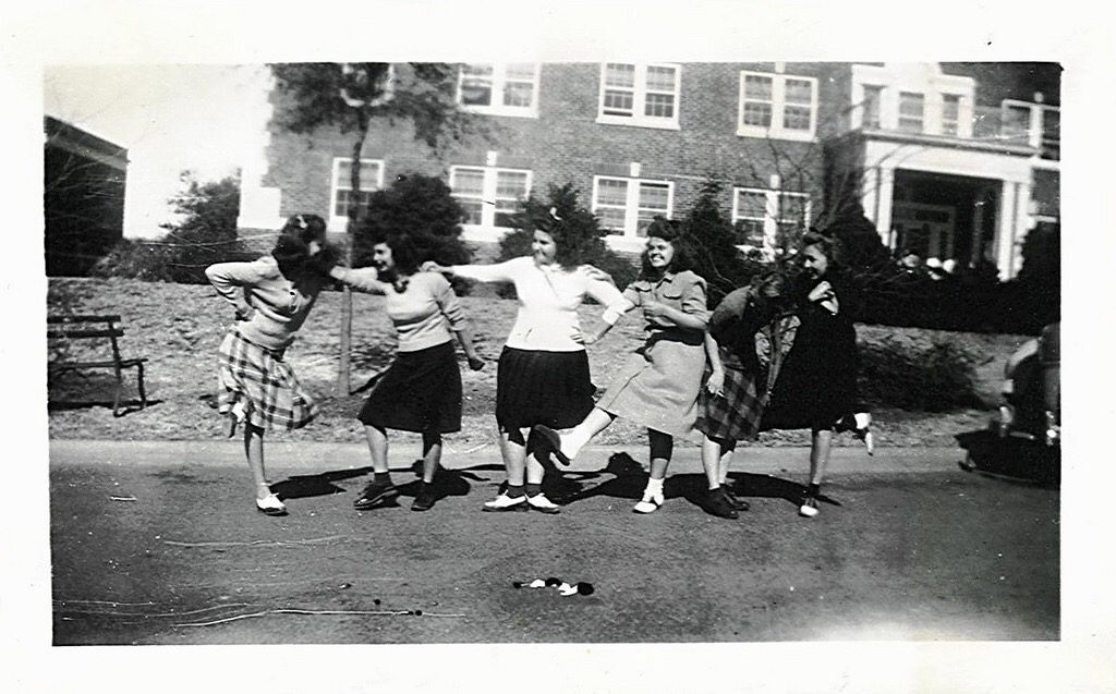 1940s vintage photo of young girls in 1940s fashions playing around for the camera. 