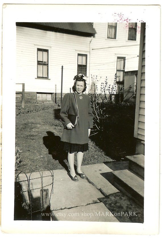 1940s vintage photo of a woman with her 1940s hairstyle covered by a hairscarf and in 1940s fashions. 