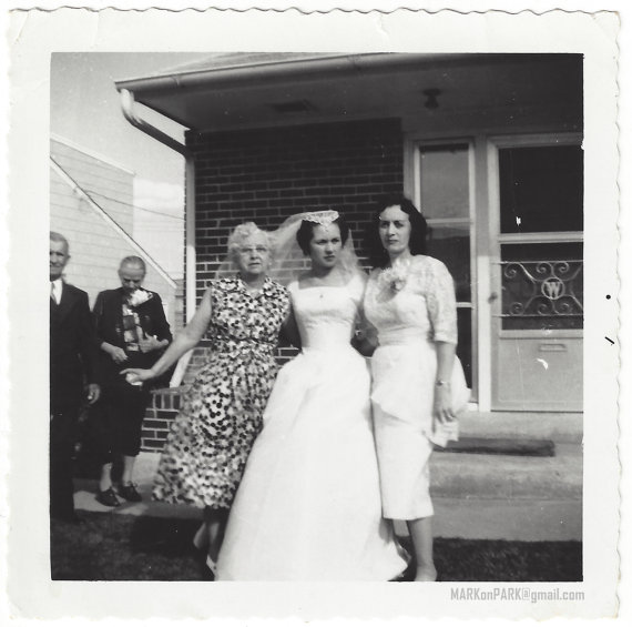 1950s vintage photo of a 1950s bride in her 1950s wedding dress with her sister in a sarong 1950s style dress and her mom. 