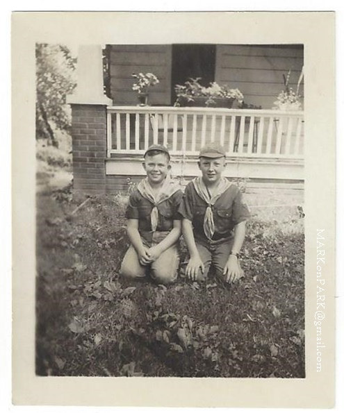 1960s vintage photo of 2 young boys in scount uniforms posing in front of their house. 