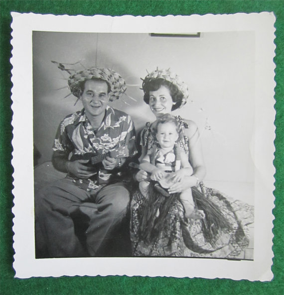 1950's vintage photo of a family in Hawaiian outfits posing together. 