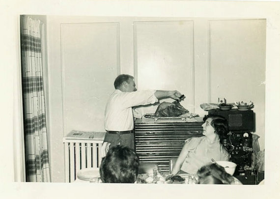 1950s vintage photo of a man carving a turkey on thanksgiving. 