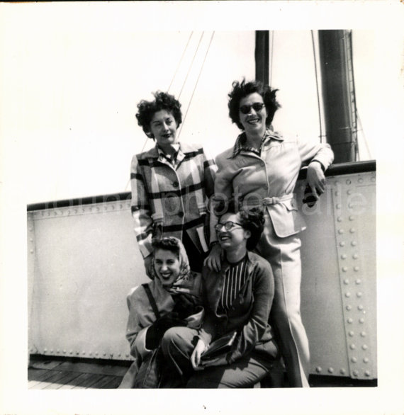 Late 1940s, Early 1950s Photo of a group of women posing together on a cruise ship. 