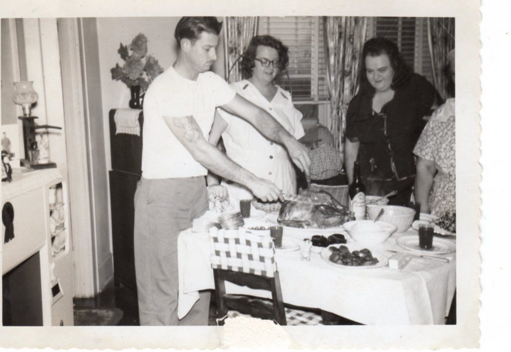 1950s vintage photo of a family carving their Thanksgiving Turkey. 