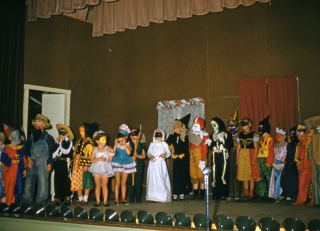 1950s School Halloween Party in 1955 featuring a number of kids in Halloween costumes. 