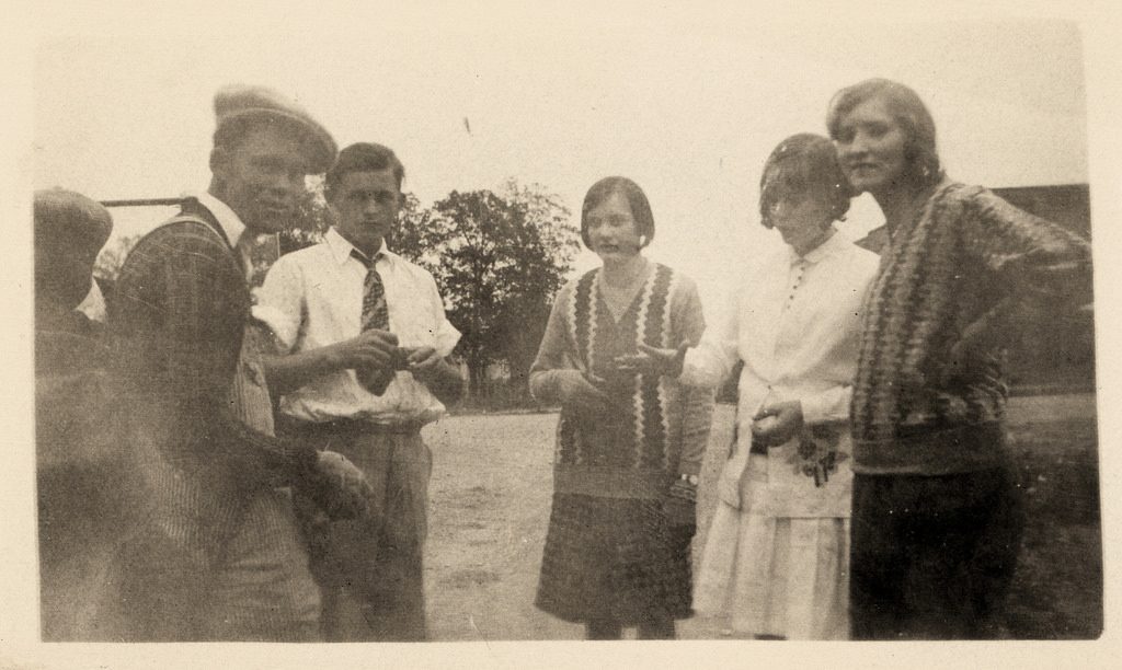 1920s vintage photo of young people in 1920s photos posing together for a photo. 