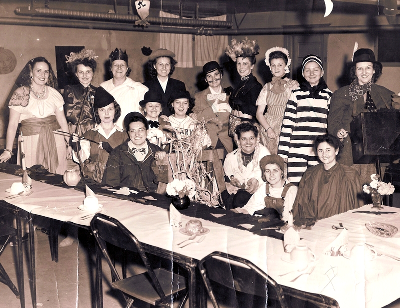 1950s vintage photo of a work Halloween party where everyone is dressed up in Halloween costumes. 