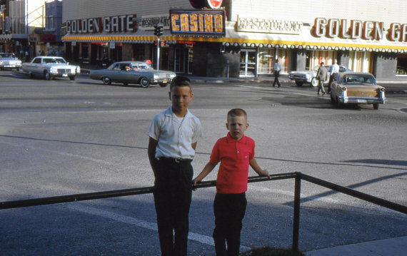 1950s vintage photo of two kids posing together across the street from the Golden Gate Casino in Las Vegas. 