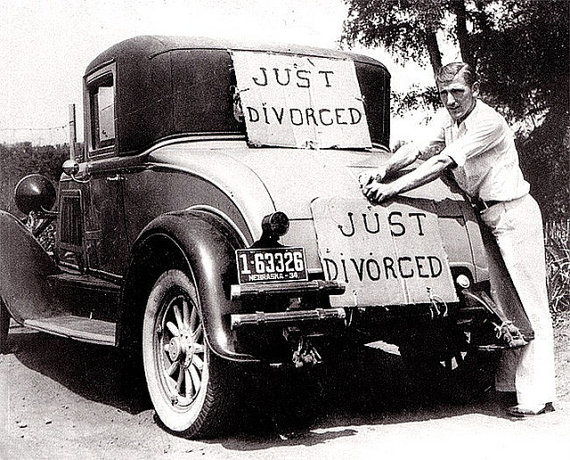 1930s Vintage photo of a man with his car putting up a sign that says "just divorced". 