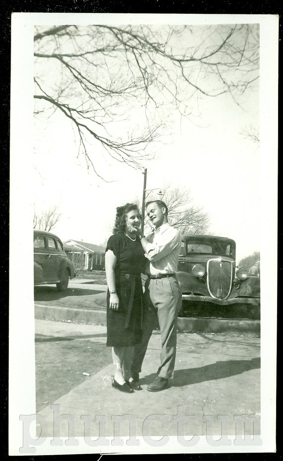 1940s Vintage Photo of a man and woman joking around with each other in a parking lot. 