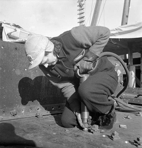 1940s vintage photo: ww2 canadian woman working for the war effort -January 1943-Mrs. Mackay using a Riveting gun at a shipyard in Pictou, Nova Scotia.