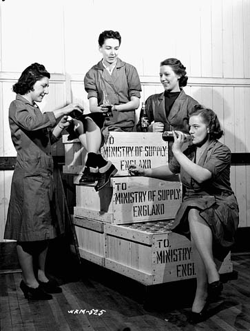 1940s vintage photo: ww2 canadian woman working for the war effort - Group of female workers enjoying a break from their work at a munitions plant.