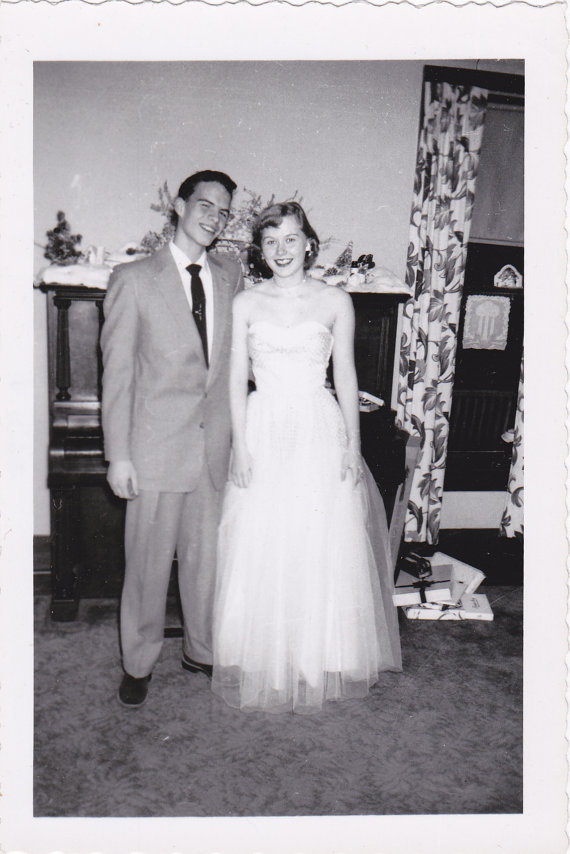 1950s vintage photo of a 1950s couple dressed for winter formal in their beautiful 1950s fashions. 