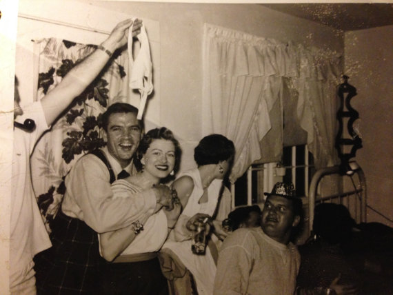 1950's new years eve vintage party image featuringa group of people in 1950s fashions goofing around. 