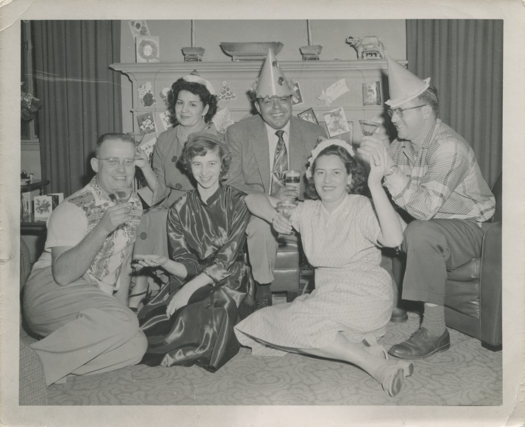 1950s Vintage photo: vintage New Years Eve Party of a group with party hats taking a photo together. 