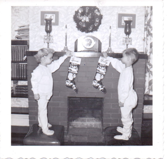 vintage image of kids hanging stockings by the fire in their onsies. 1940s / 1950s vintage photo. 