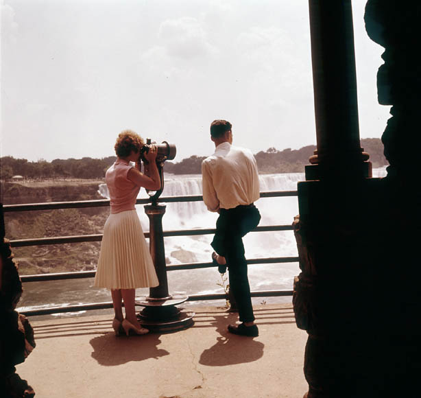 1960s vintage image at Niagara Falls Canada of a couple looking at the falls in 1960s fashions. 