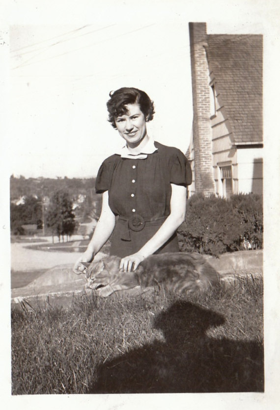 1930s vintage image of a women in a 1930s dress with a cat