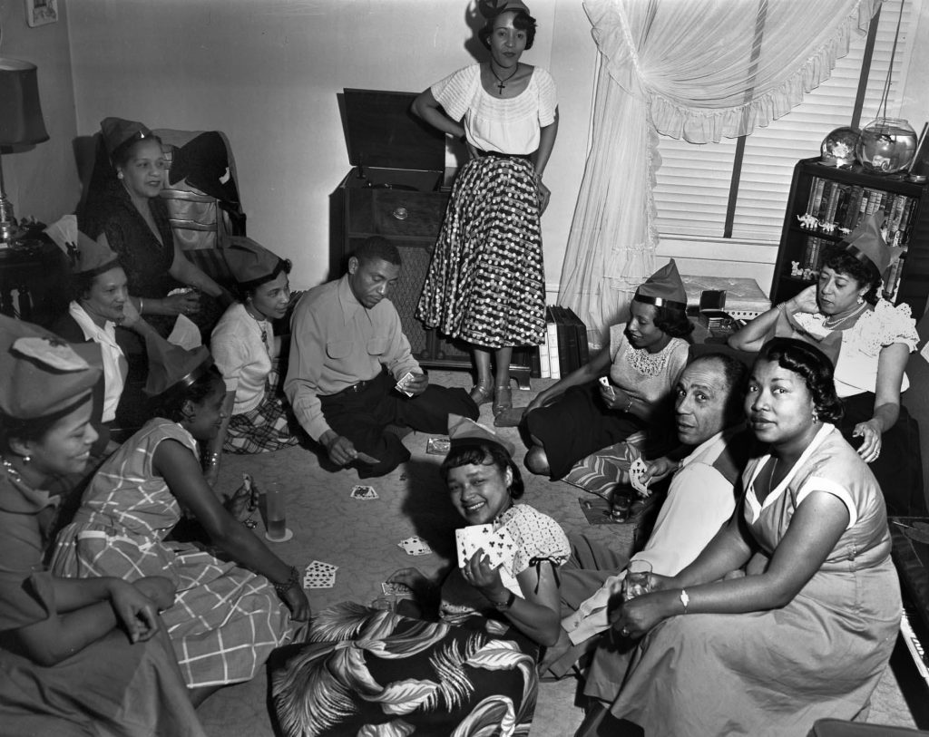 1940s vintage photo of a group of young Black women sitting at a house party in late 1940s clothing.