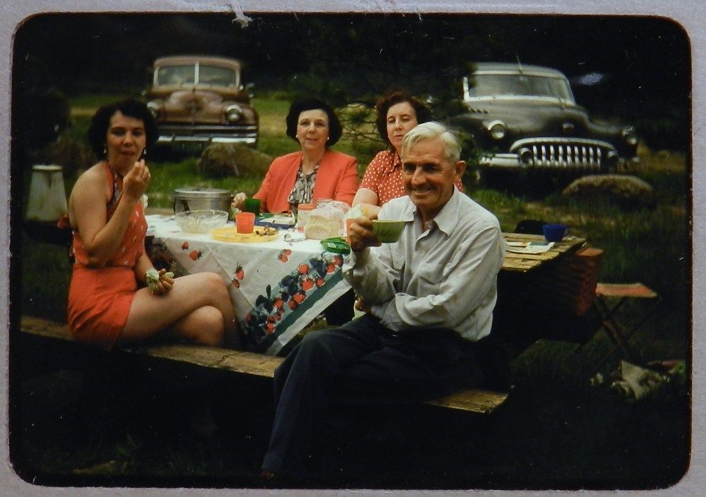 1950's vintage colour image of family enjoying a picnic together. 