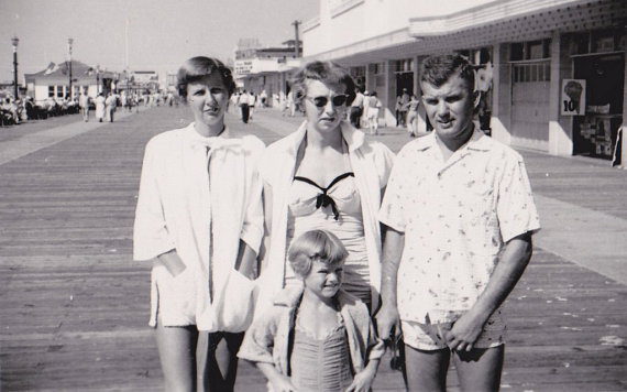 1950s vintage phot of a family in 1950s summer time fashions posing together on the boardwalk.