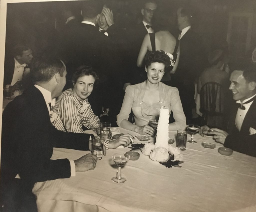 1940's vintage photo of couples at a fancy dinner in 1940s fashions and 1940s hairstyles. 