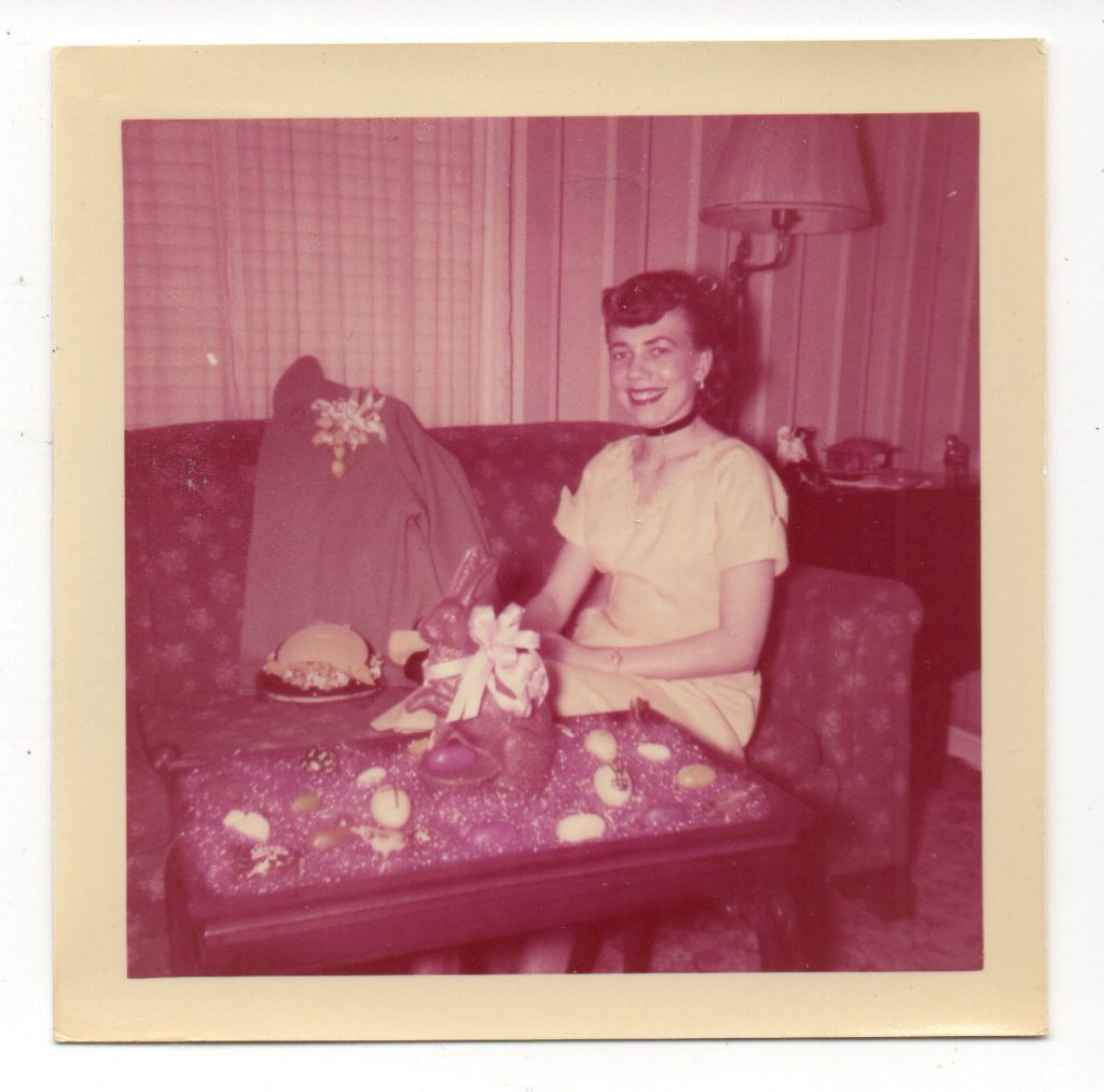 1950s Vintage photo from Easter 1950s. Featuring a woman in 1950s fashions posing with a chocolate easter bunny