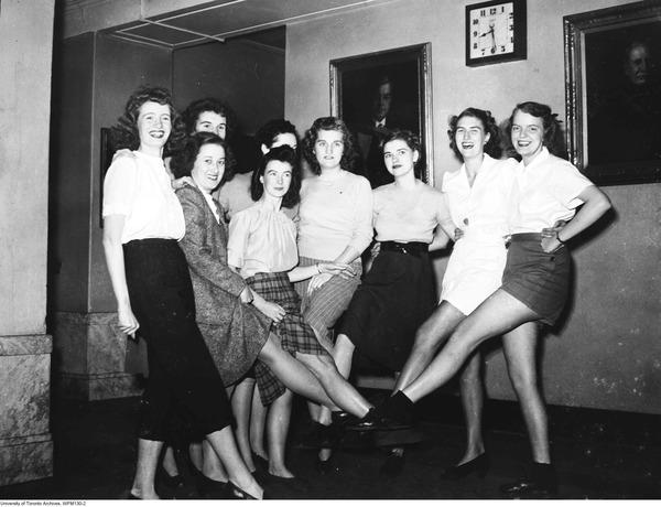 1940s image of young women in 1940s outfits doing a kickline pose for the camera. A group of dancing Dentettes in rehearsal for the 1946-47 Dentatics musical review. 